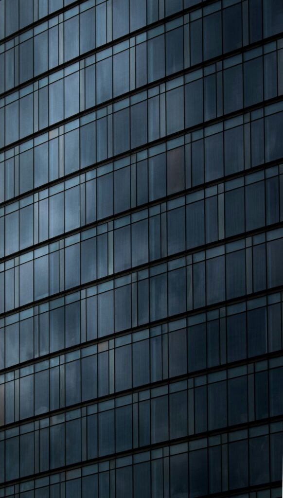 an airplane flying in front of a very tall building